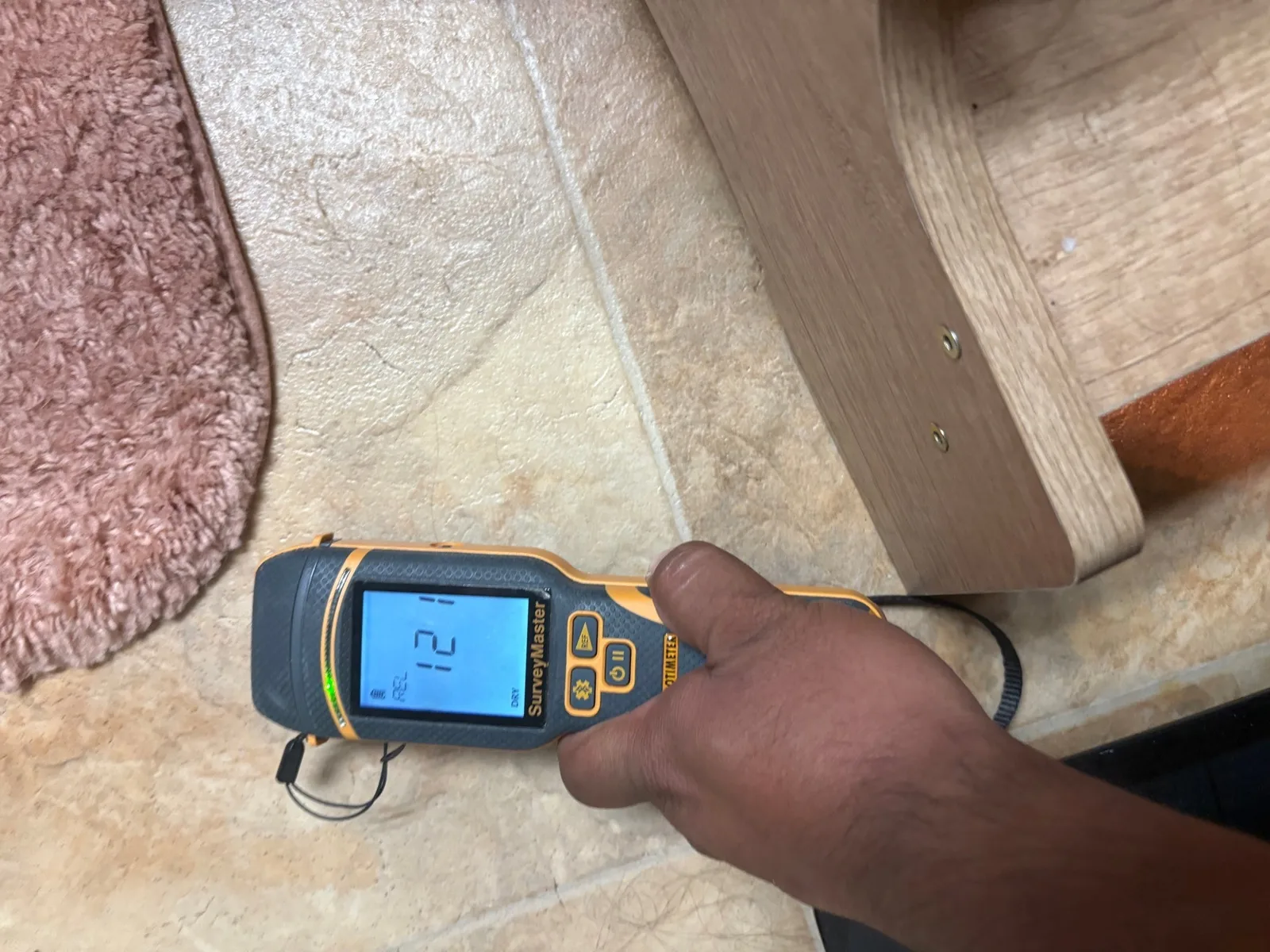 Moisture meter reading on the upstairs bathroom floor where the ceiling leak originated